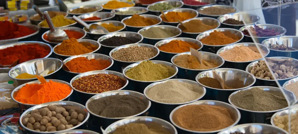 A diverse selection of colorful spices, hinting at their culinary origins